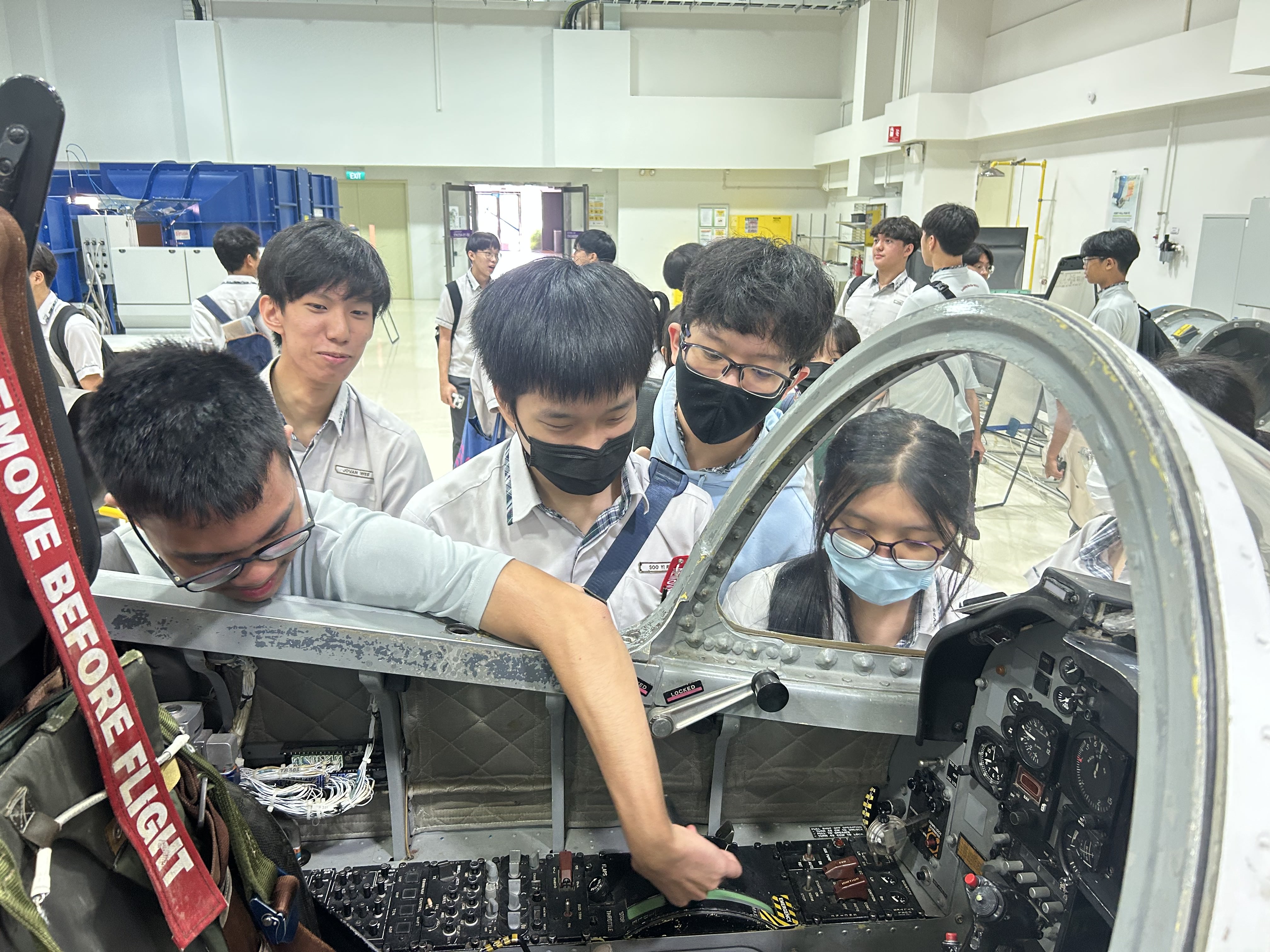 Students exploring the pilot controls inside a plane's cockpit